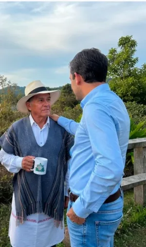 Alvarán conversa con un campesino con sombrero y ruana durante un recorrido