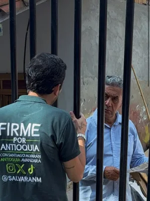 Alvarán conversa con un vecino a través de la reja de su casa